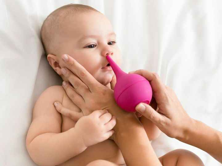 Newborn baby getting nose cleaning with cleaner