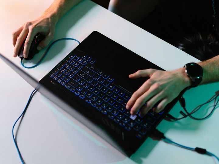 Side view man hands using laptop typing on keyboard using mouse on white table