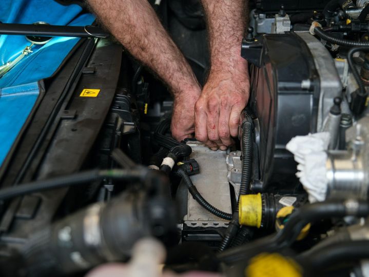 Car mechanic hands replacing intercooler on a car engine.