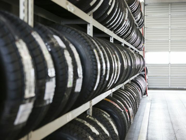Long row of new tires on a rack in an auto repair shop