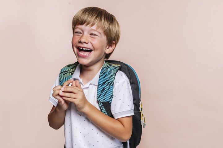 Happy smiling school boy with backpack