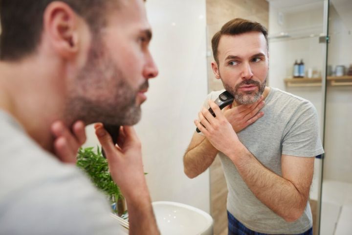 Man with electric razor shaving