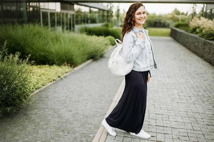 Happy pretty young brunette woman with backpack