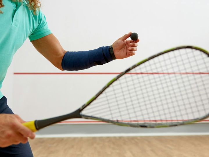 Crop shot of male athlete in sportswear playing squash