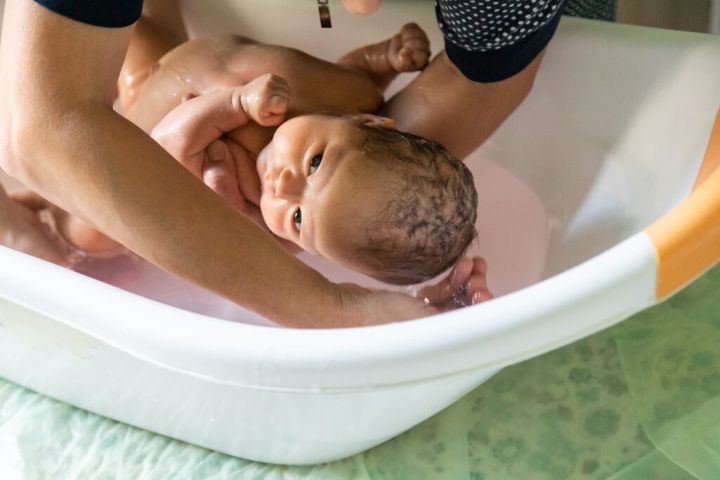 Closeup of newborn baby bathing in a baby bath