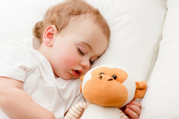 beautiful sleeping baby with monkey toy