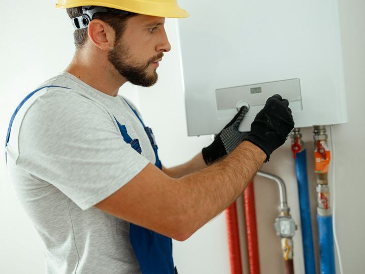 Serious technician setting the new gas boiler for hot water and heating