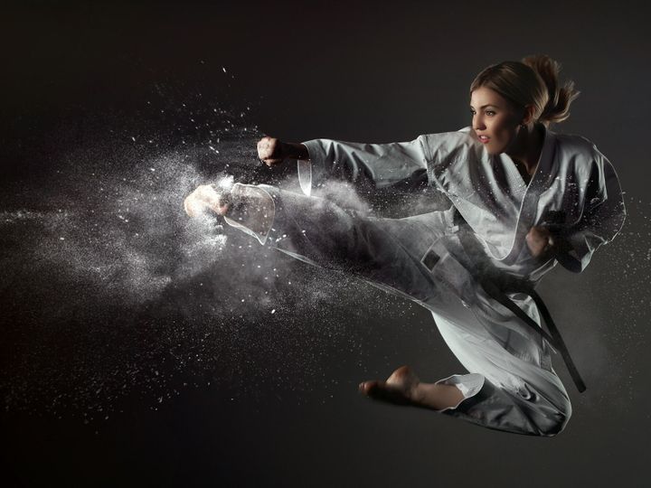 Karate girl bounces and makes a kick