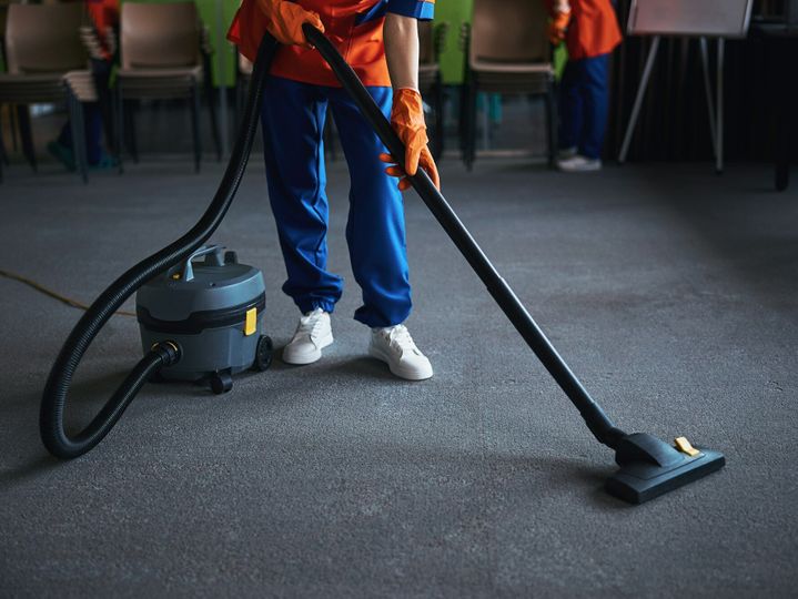 Cleaning lady using a canister vacuum cleaner