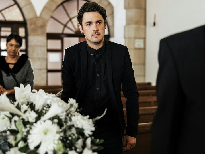 Funeral, death and grief with a man pallbearer carrying a coffin in a church during a ceremony. Flo