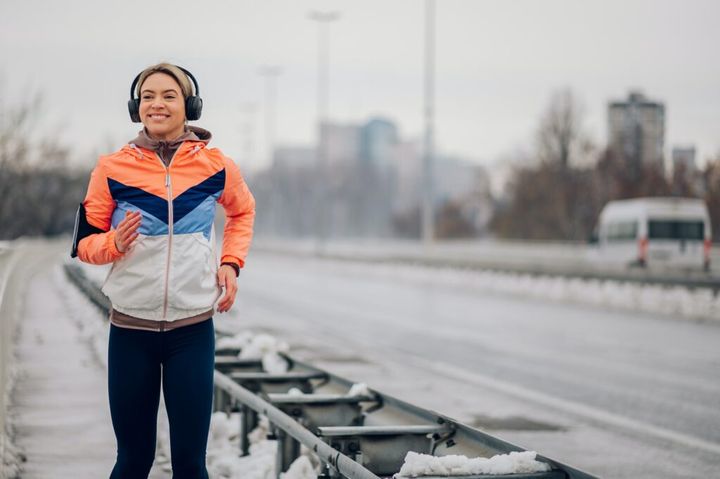 Woman running on the bridge at winter and snow.