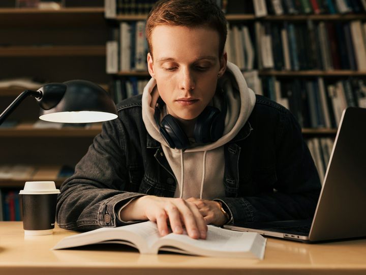 Male student reading from a book