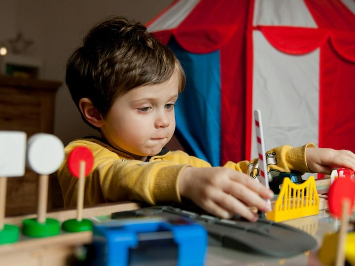 Little toddler boy play in trains at home