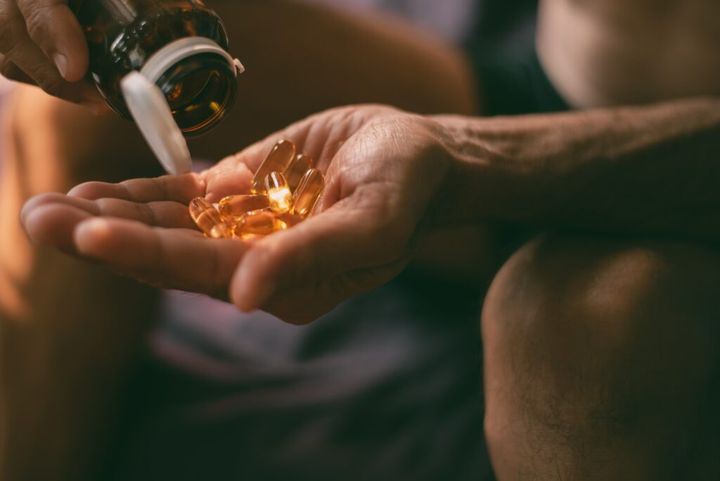 Pills or vitamins in the hands of a middle-aged man