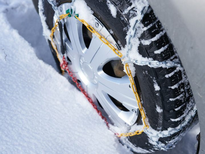 snow chain on a wheel in deep snow in winter