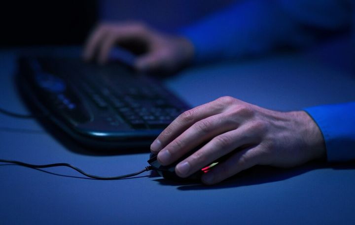 Male hands on computer keyboard and mouse