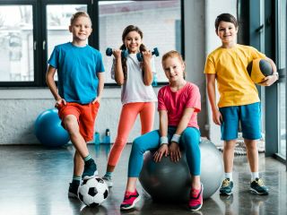 Laughing preteen kids posing with sport equipment