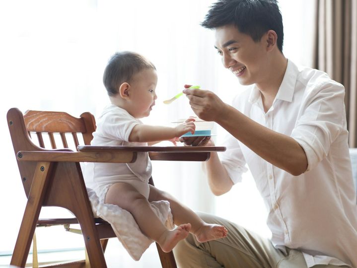 Young father feeding baby