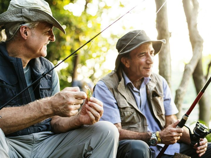 Senior friends fishing by the lake