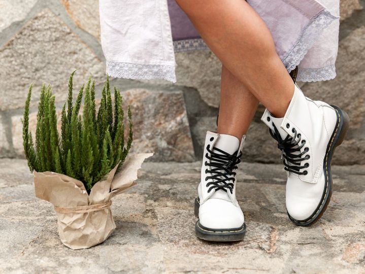 Female legs in rough white boots and potted plant