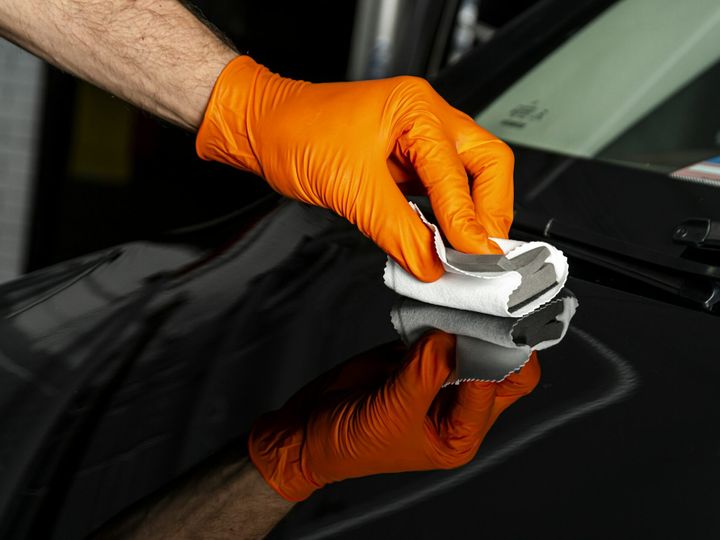 Car polish wax worker hands polishing car