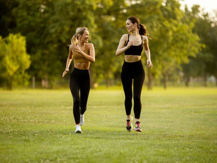 Two pretty young women running in the park