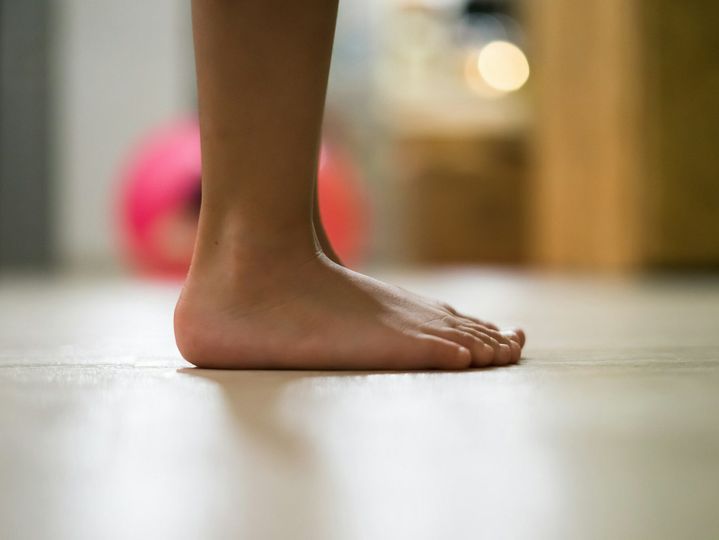 Children's bare feet. Child's bare feet on the wooden floor