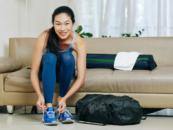 Woman putting on sneakers