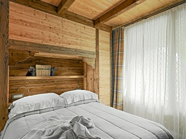 Interiors of a Rustic Bedroom with Wooden Wainscoting and Wooden Ceiling