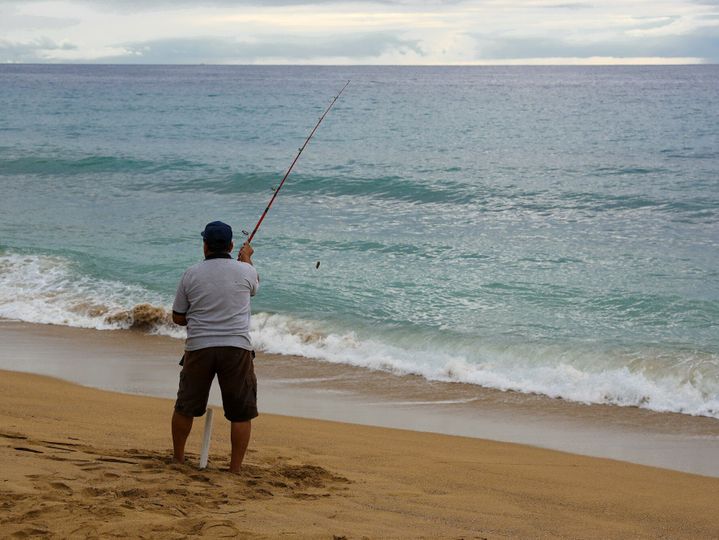 Fisherman with a rod on the beach.