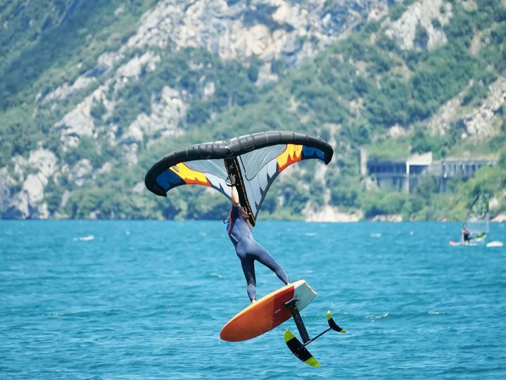 Male using an inflatable wing with a board on the lake Garda in Italy