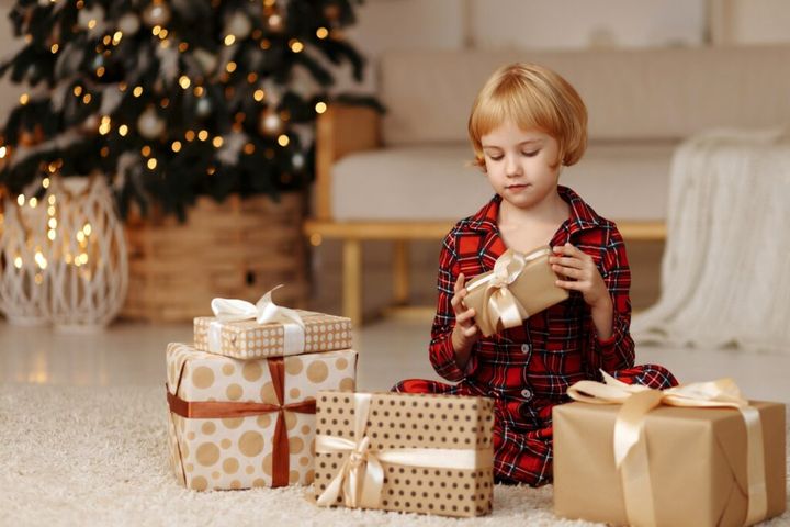 The child happily holds a gift in his hands.