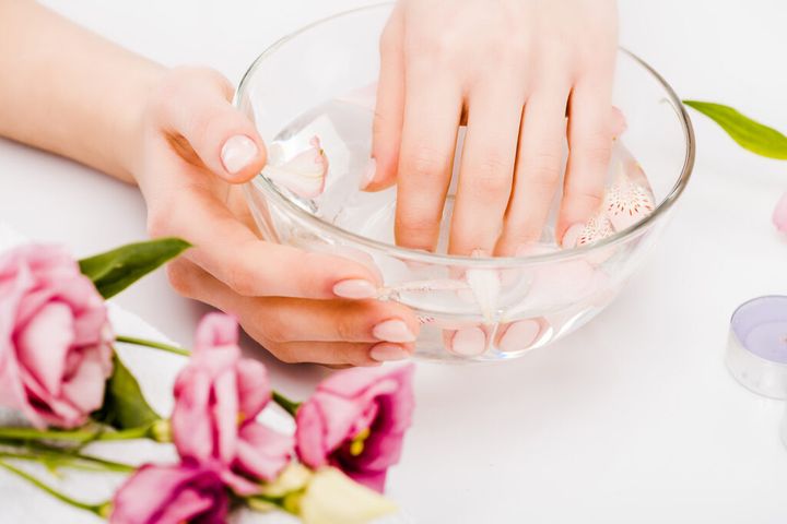Partial view of woman with elegant manicure doing hand care routine