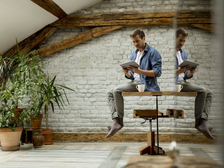 Handsome young man using digital tablet while sitting in the rustic room