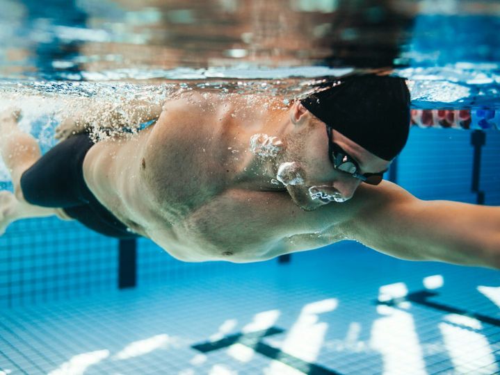 Professional male swimmer swimming in pool