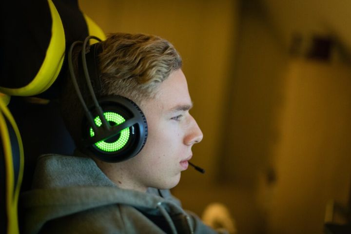 a young man with headphones on playing computer games