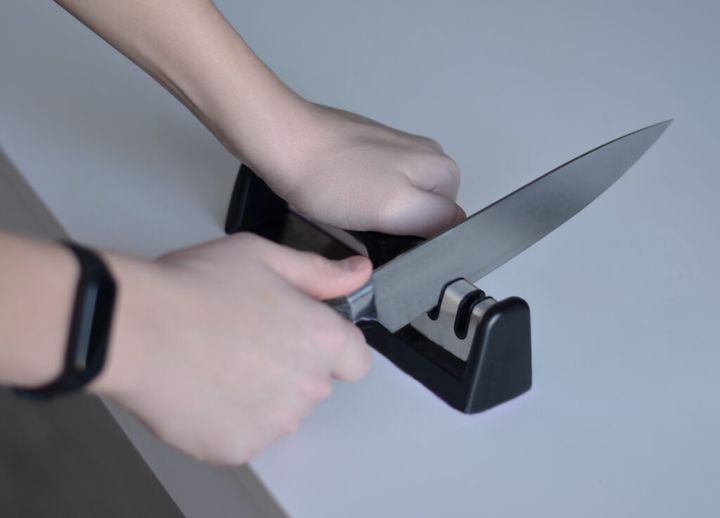 teenager sharpening a knife