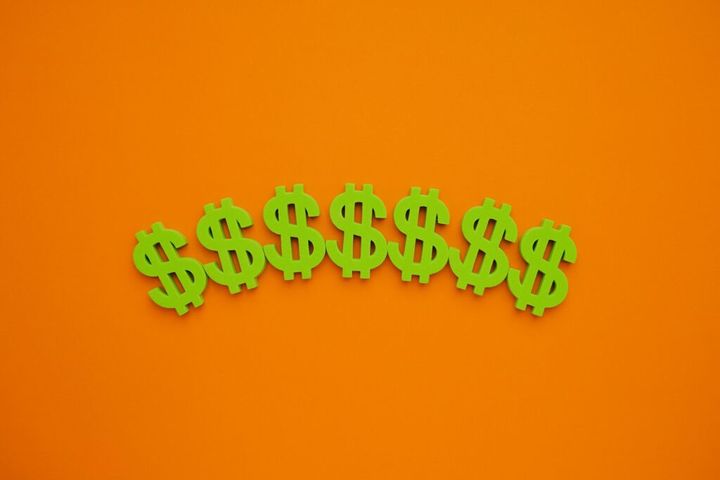 American dollar symbol on orange background. Green money flatlay