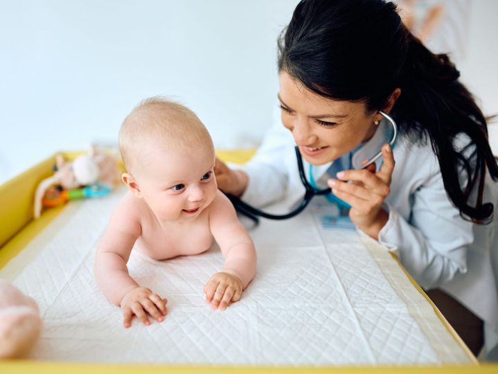 Smiling baby during a visit at pediatrician.