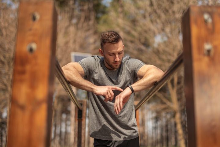 Man checking data on smartband after workout