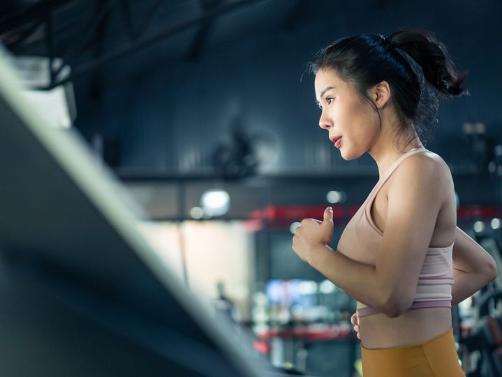Asian young athlete sportswoman practice workout to maintain muscle in gym or fitness club.