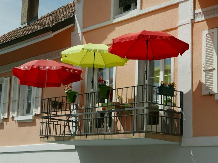 Balcony with red and yellow umbrellas under the clear sky