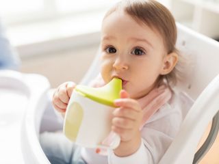 dziecko pijące wodę z kubka