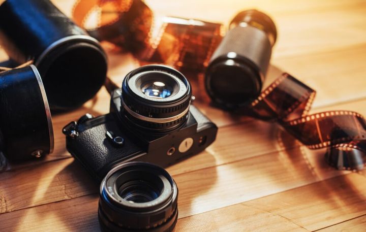 Old film camera and a roll of on wood