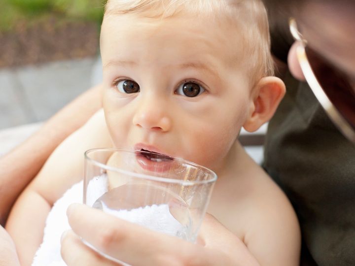 dziecko pijące wodę z kubka
