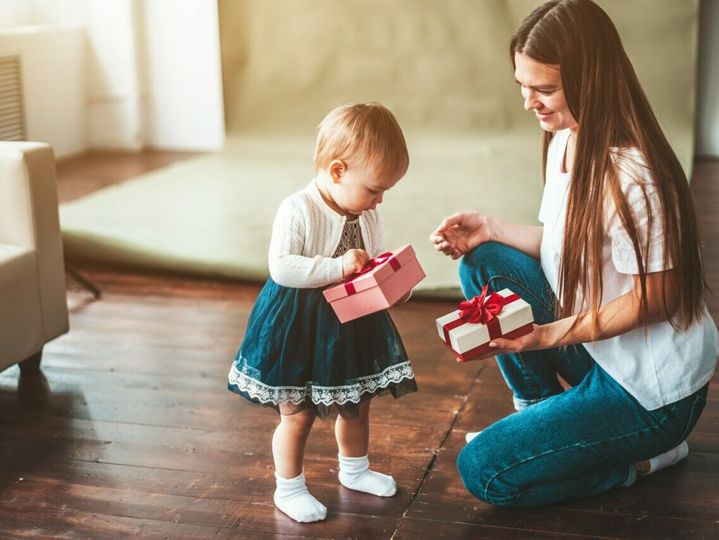 Mother and child holding gift boxes.