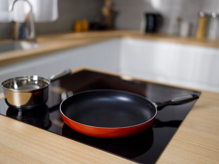 Frying pan and sauce pan on induction hob in modern kitchen