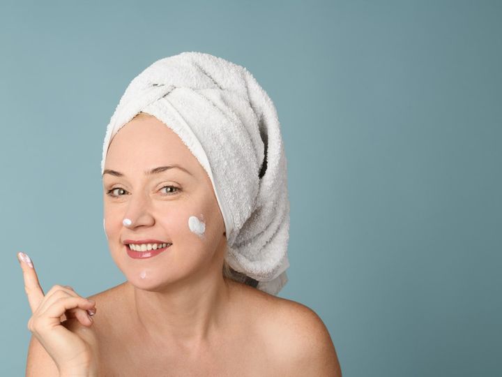 Cheerful woman woman applying skin cream