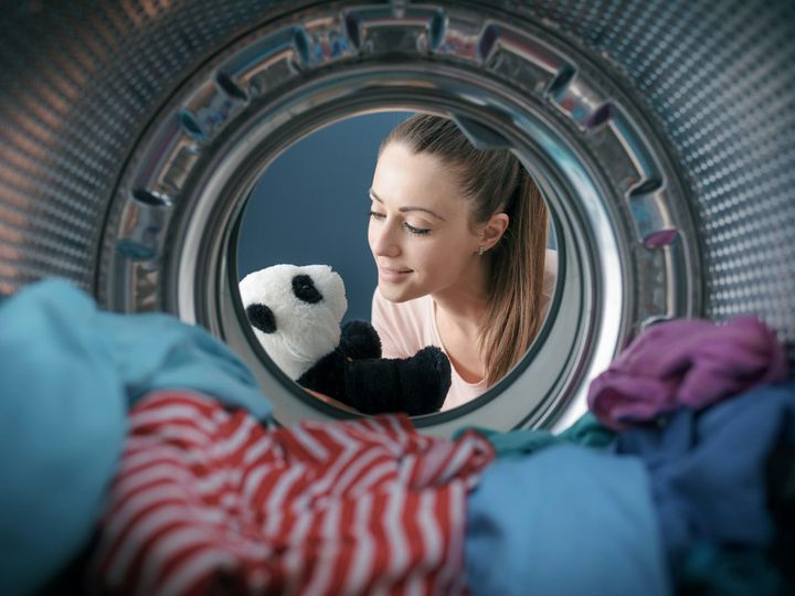 Woman washing a plush in the washing machine