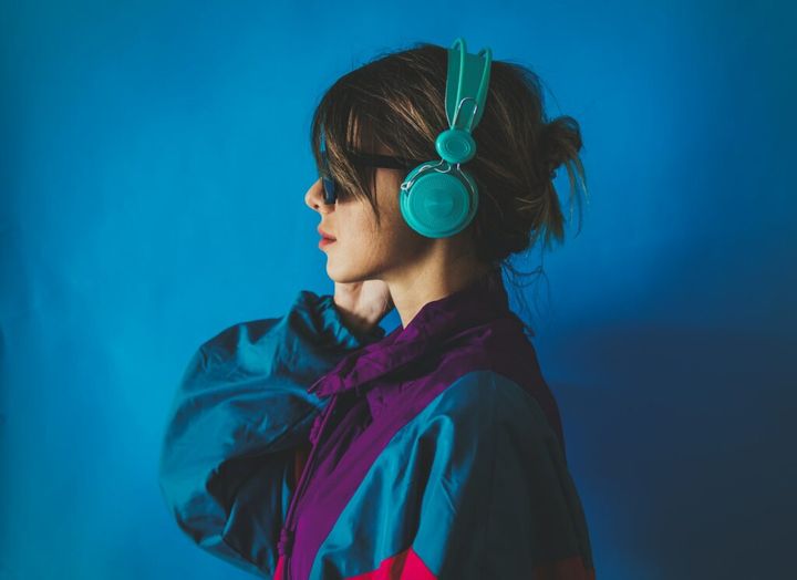 Young woman in 90s style jacket and with headphones